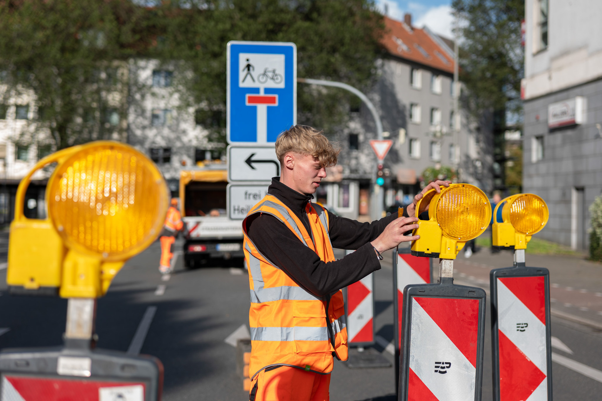 Eine Person richtet eine Bischofsmütze auf einer Bake zur Verkehrssicherung Dortnund.