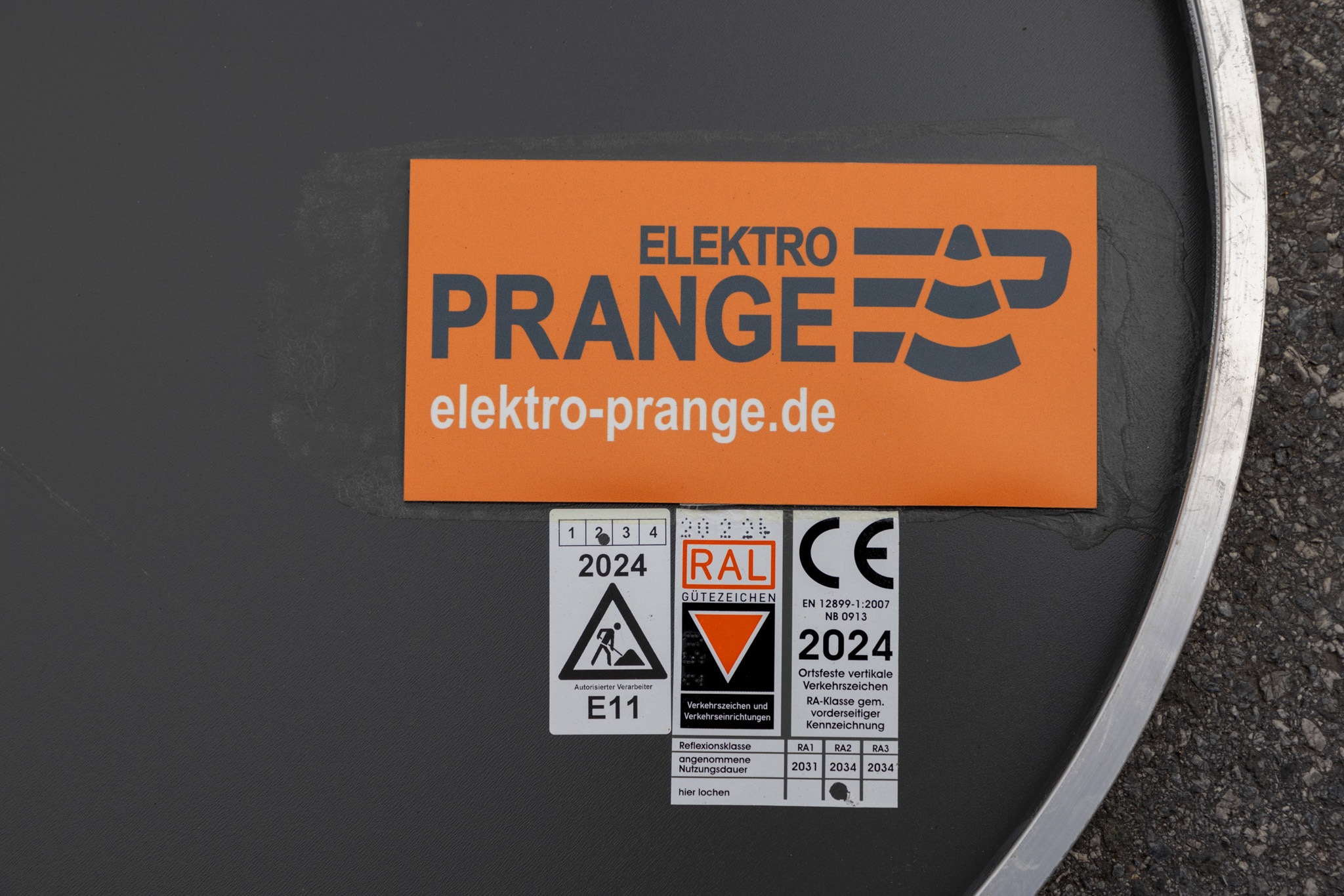 Die Rückseite von einem Verkehrsschild der Firma Elektro Prange mit RAL Gütezeichen.